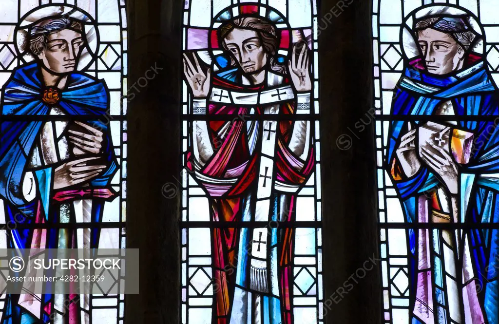 England, Tyne and Wear, Jarrow. East wall stained glass window in the Chancel of St Pauls Monastery and church, depicting St Paul, Risen Christ and the Venerable Bede.