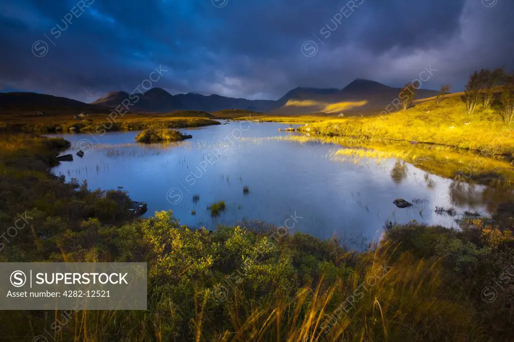 Scotland, Highland, Rannoch Moor. Lochan an Stainge located on Rannoch Moor with the dominating peak of the Black Mount and surrounding mountains in the distance.