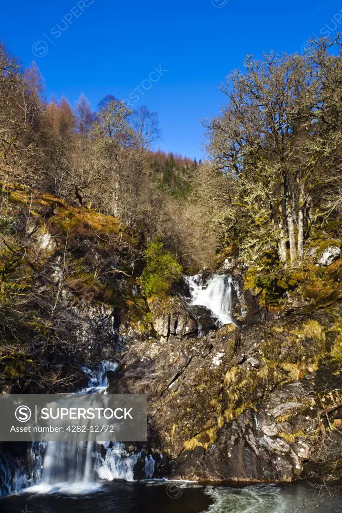 Scotland, Highland, Eas Chia-aig waterfall. The Eas Chia-aig waterfall running through a tranquil expanse of native woodland.