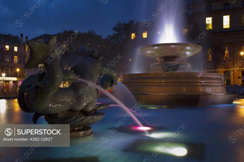 England, London, Trafalgar Square. Flood lit fountains in Trafalgar Square at dusk.