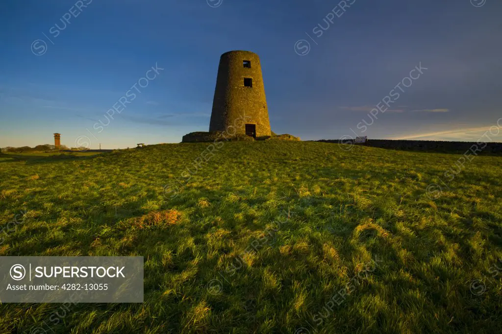 England, Tyne and Wear, Cleadon Hills. The rising sun spotlights the old mill in Windmill Field, located within the Cleadon Hills Local Nature Reserve.