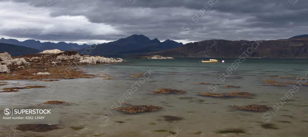 Scotland, Highland, Ord. A panoramic view from the shore towards a small boat moored on Loch Eishort on the Isle of Skye.