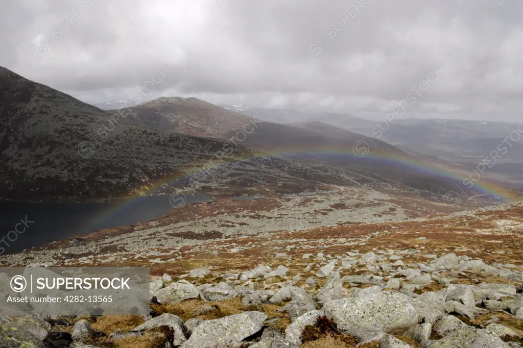 Scotland, Aberdeenshire, Cairngorms. A rainbow over Lochan na Gaire in a corrie on Lochnagar.