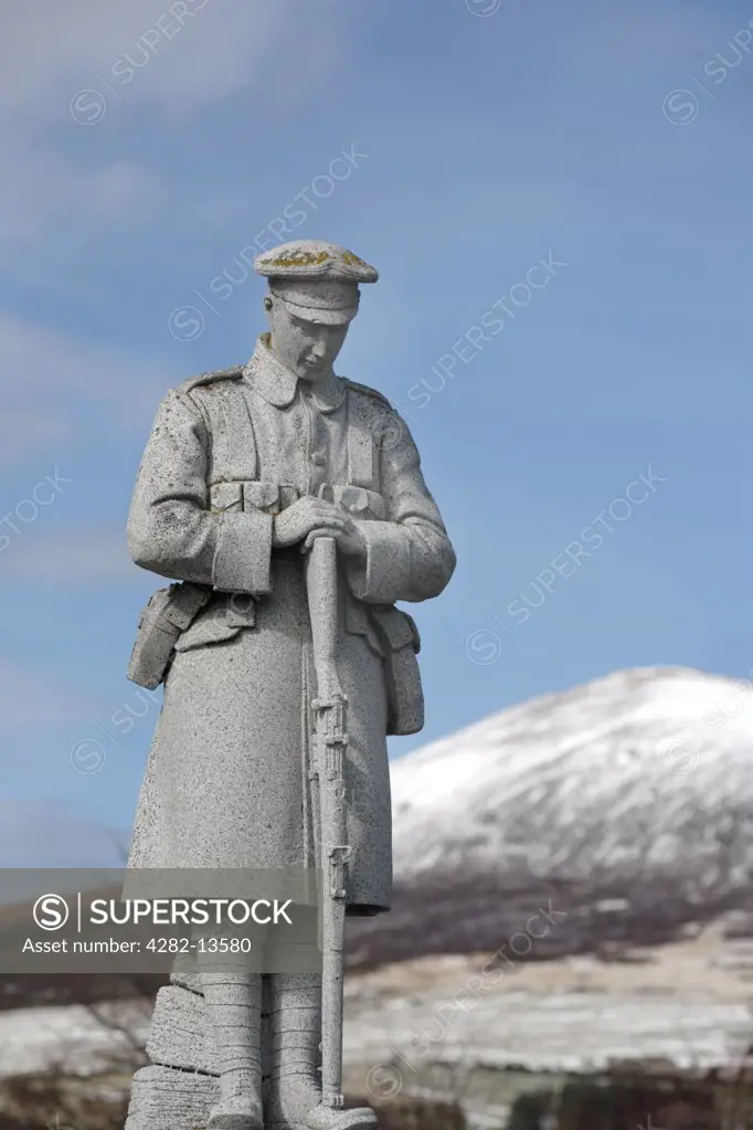 Scotland, Aberdeenshire, Rhynie. World War One memorial at Rhynie with the snow covered Tap O' Noth Hillfort in the background.