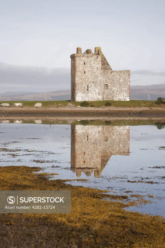 Scotland, North Ayrshire, Lochranza. The ruin of Lochranza Castle reflected in  Lochranza on the Isle of Arran.