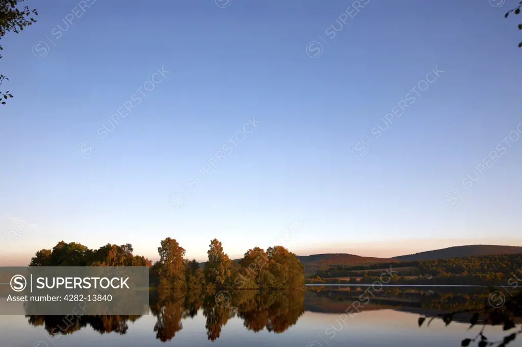 Scotland, Aberdeenshire, Dinnet. Loch Kinord and Castle Island on a still autumn evening.