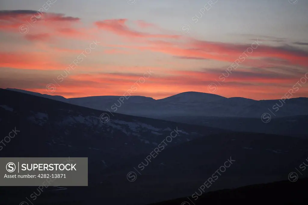 Scotland, Aberdeenshire, Cairngorm National Park. A view at dusk over the Cairngorms with a red sky sunset.
