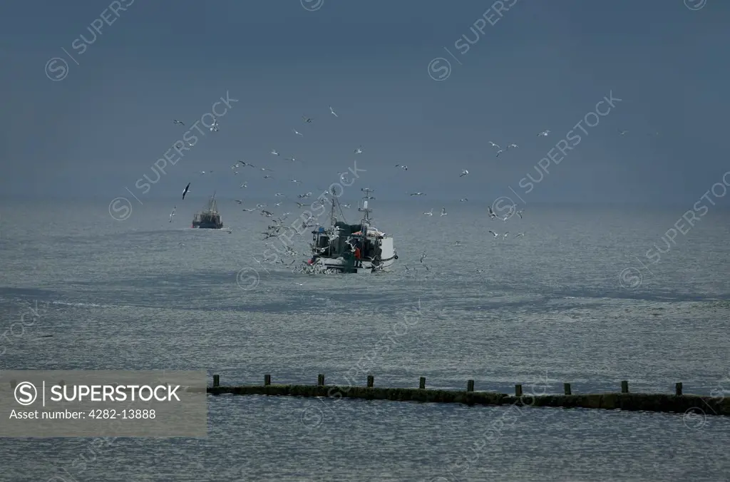 Scotland, Inverness-shire, Burghead. A fishing boat leaving on the dawn tide.