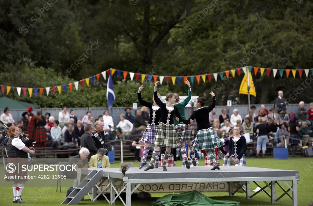 Scotland, Aberdeenshire, Strathdon. Female highland dancers performing for the crowds at the Lonach Highland Games.