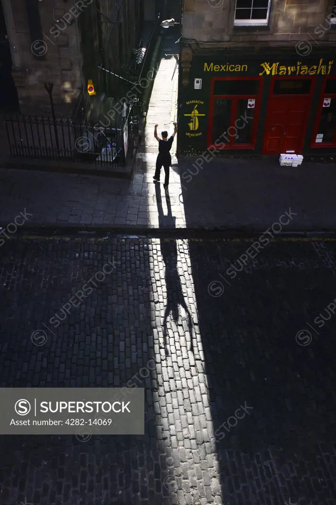 Scotland, Midlothian, Edinburgh. A man silhouetted in Victoria Sreet in the Old Town of Edinburgh.