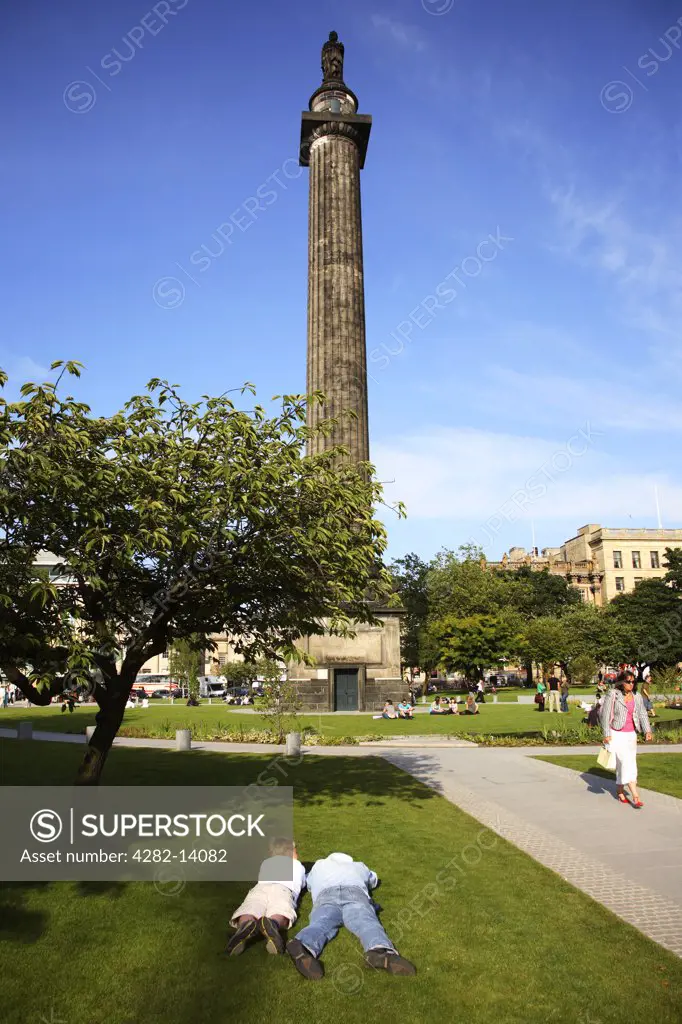 Scotland, City of Edinburgh, Edinburgh. People relaxing in the sun beside the Melville monument in Edinburgh.