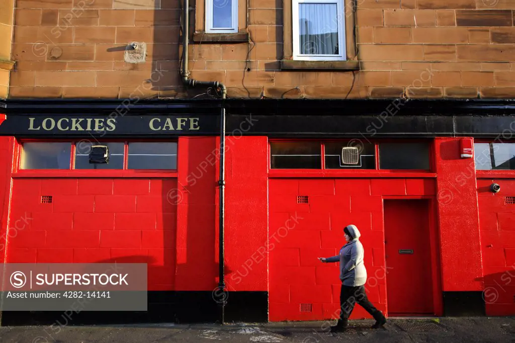 Scotland, City of Edinburgh, Edinburgh. A passer by outside a cafe in Newhaven.