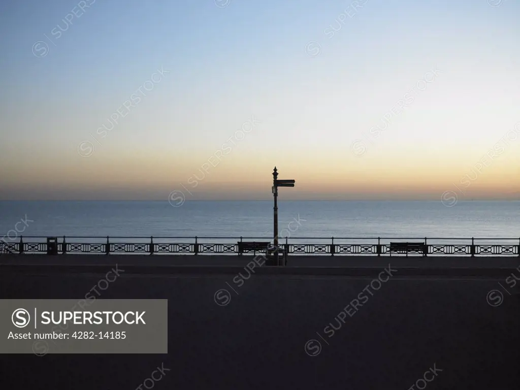 England, East Sussex, Hove. A view out to a calm sea at dusk from the promenade in Hove.