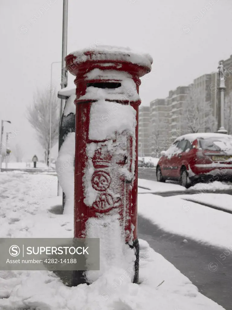 England, East Sussex, Hove. A red post box with a covering of snow in the streets of Hove.