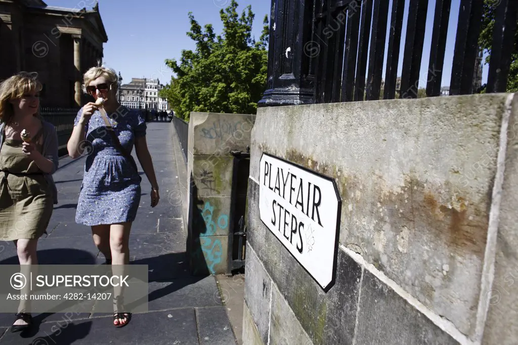 Scotland, City of Edinburgh, Edinburgh. Two young women walking towards Playfair Steps eating ice creams.