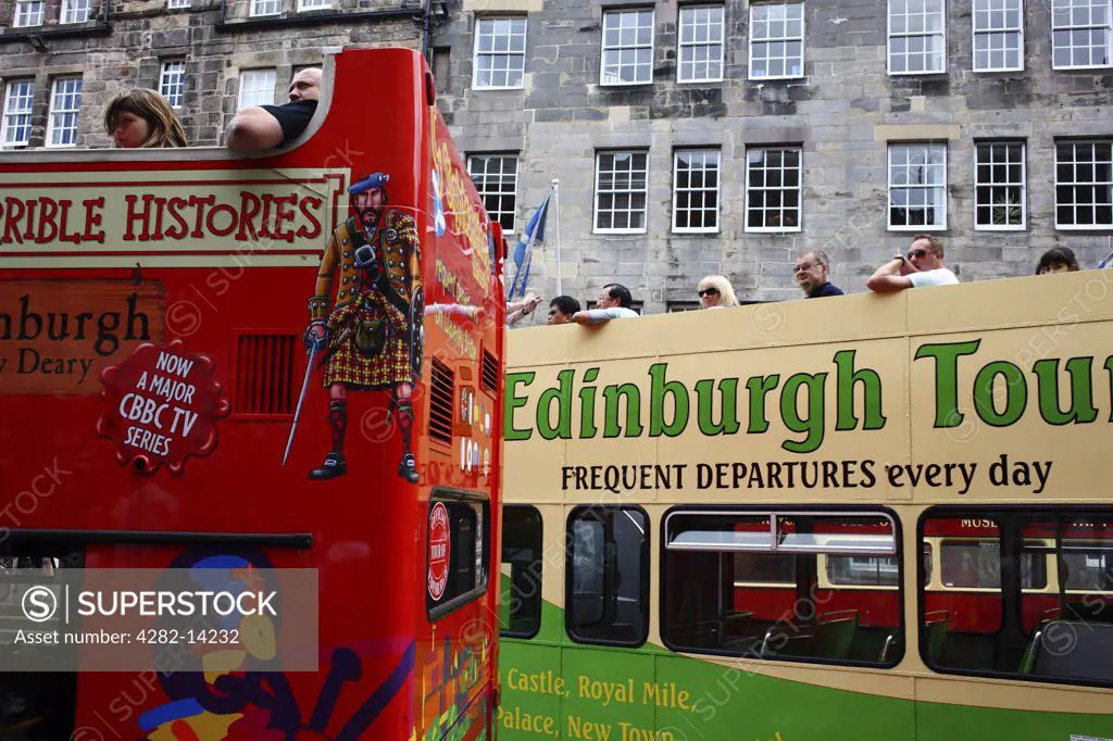 Scotland, City of Edinburgh, Edinburgh. Tourists onboard double decker sightseeing buses in the Old Town of Edinburgh.
