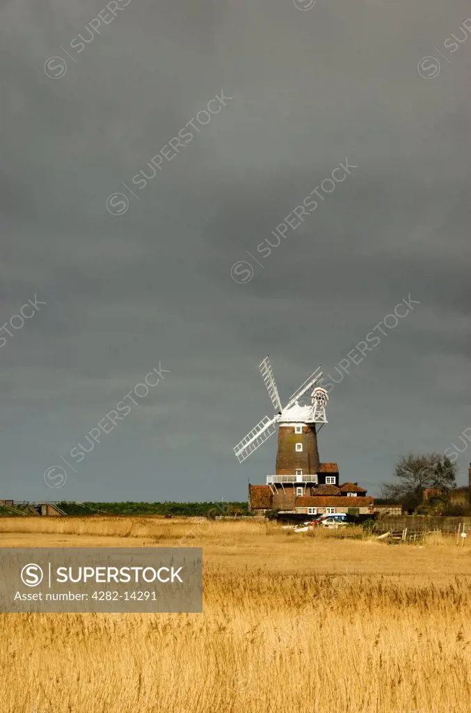 England, Norfolk, Cley Next The Sea. A view over a field to Cley Windmill.