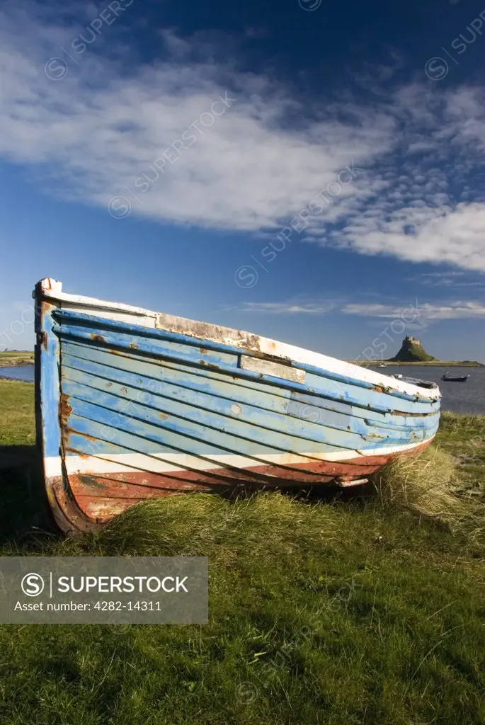 England, Northumberland, Lindisfarne. A small fishing boat and a view out to The Holy Island of Lindisfarne.