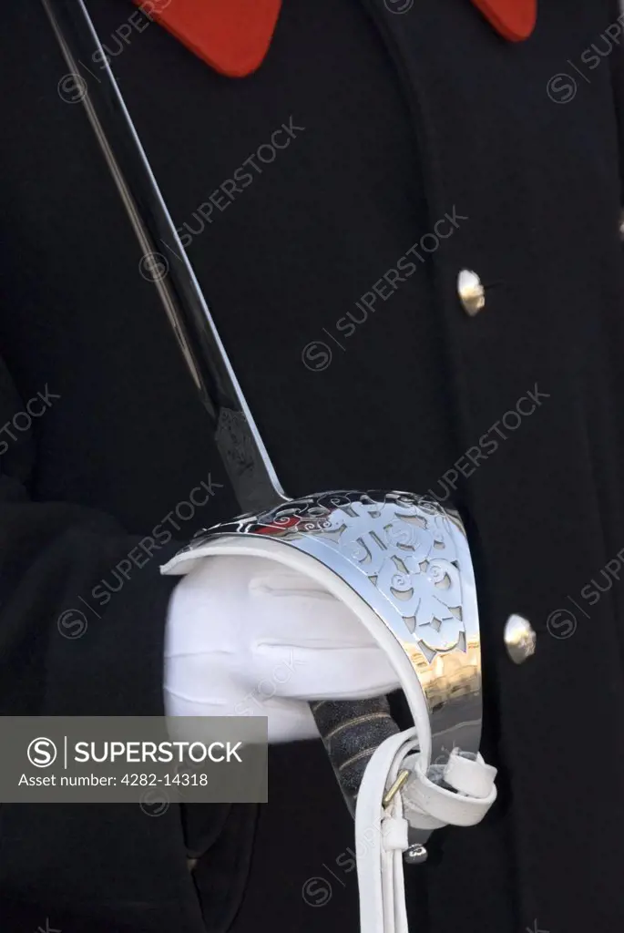 England, London, Buckingham Palace. Detail of Household Cavalry guard's uniform and sword handle. The Household Cavalry provides the Queen's Life Guard daily and Sovereign's Escort on state occasions.
