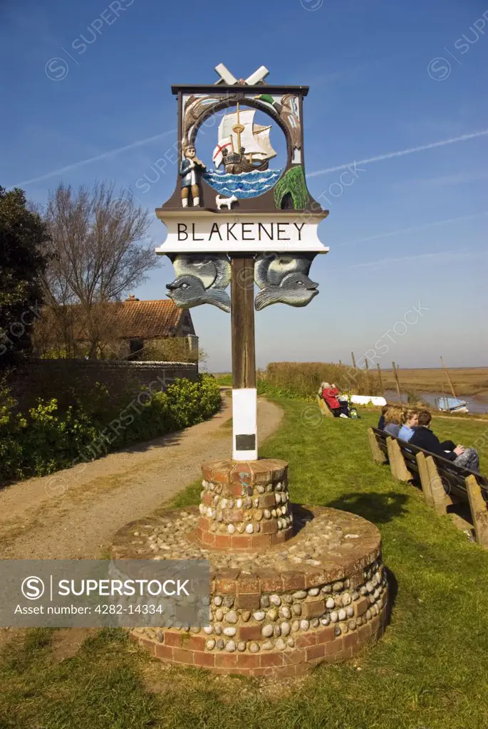 England, Norfolk, Blakeney. Old village sign in Blakeney. The sign shows a fiddler and his dog and the story goes that this fiddler went to explore a tunnel with his dog and both were never seen again.