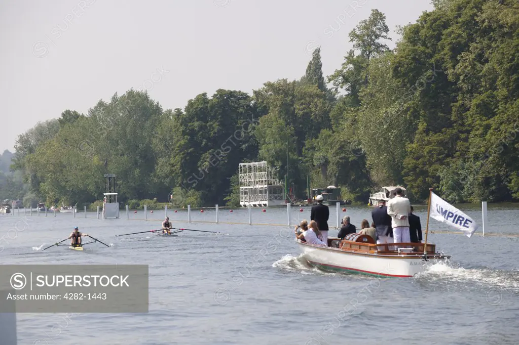 England, Oxfordshire, Henley-on-Thames. The umpire's boat following a race up the course at the annual Henley Royal Regatta.