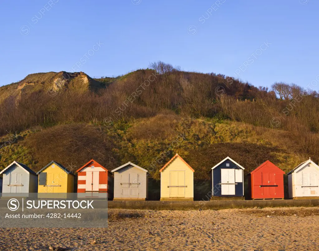 England, Norfolk, Cromer. Colourful beach huts in the early morning light on Cromer beach.