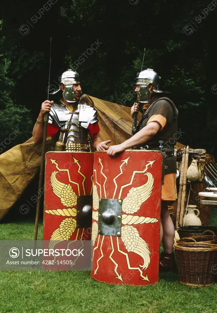 Wales, Denbighshire, Loggerheads Country Park. Two members of the Ermine Street Guard re-enactment society dressed as Roman legionaries standing outside their goatskin tent.