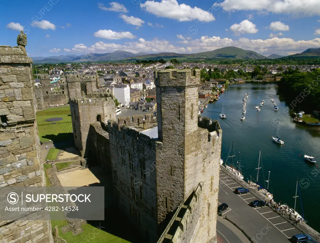 Wales, Gwynedd, Caernarfon. Looking South East from the Eagle Tower of Caernarfon Castle over the Queen's Tower, Slate Quay and the River (Afon) Seiont towards Moel Eilio and other peaks of Snowdonia.