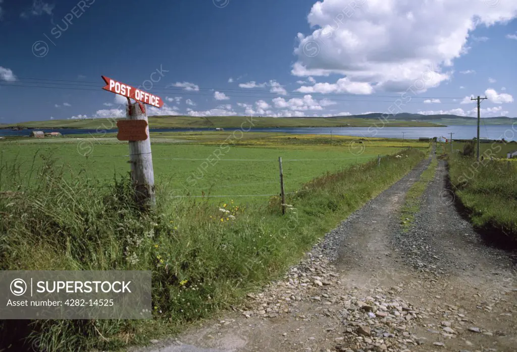 Scotland, Orkney, Hoy. Sign beside the B9049, at the NE of Hoy, pointing down the track to Garson post office beside Burra Sound, with Graemsay island and Orkney Mainland in the distance.