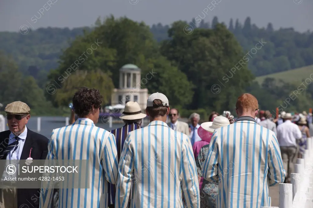 England, Oxfordshire, Henley-on-Thames. Rowing club members and spectators making their way along the riverside path at the annual Henley Royal Regatta.