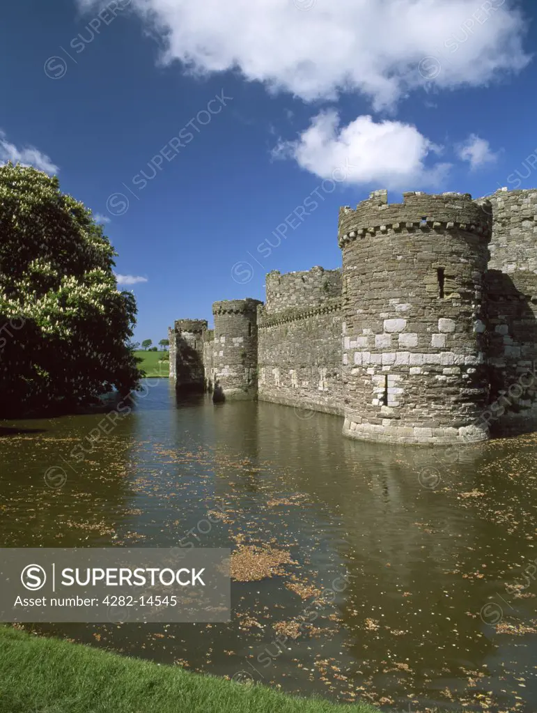 Wales, Anglesey, Beaumaris. Looking across the moat at the western outer curtain wall and towers of Edward I's Beaumaris Castle.