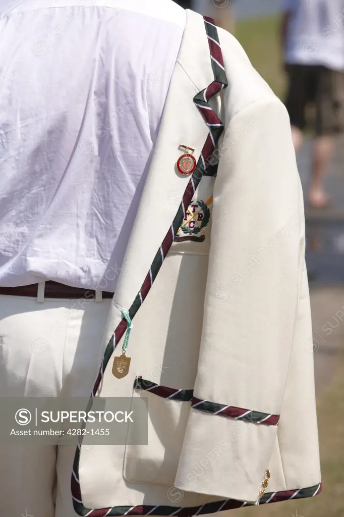 England, Oxfordshire, Henley-on-Thames. A rowing club member with his blazer over his shoulder at the annual Henley Royal Regatta.
