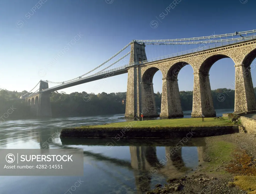 Wales, Anglesey, Menai Suspension Bridge. Looking up from the Anglesey shore of the Menai Strait at Telford's Suspension Bridge, opened to traffic in January 1826 as part of his A5 London to Holyhead coach road.