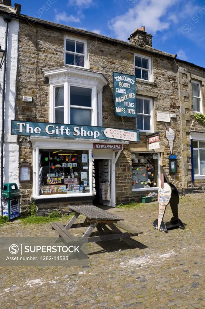 England, North Yorkshire, Reeth. Seating on a cobbled street outside The Gift Shop in Reeth in Swaledale.