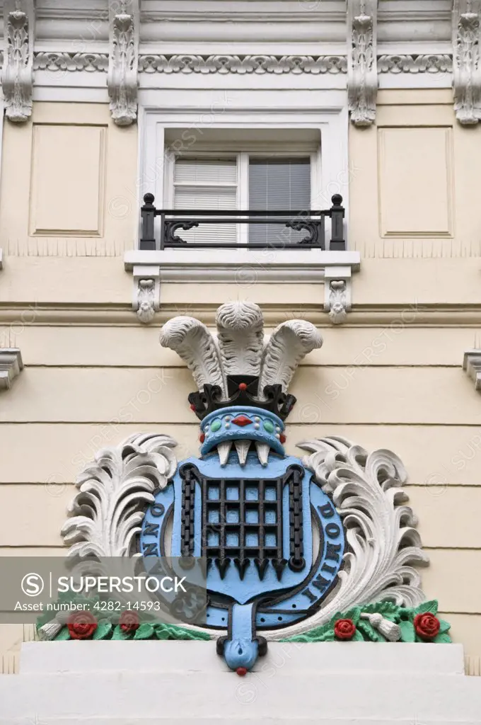 England, London, Covent Garden. A cartouche of arms, with a wreathed portcullis surmounted by the Prince of Wales's Feathers above Moss Bros in King Street, Covent Garden.