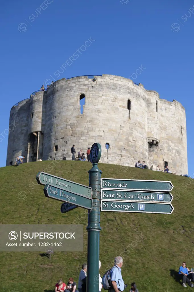 England, North Yorkshire, York. Clifford's Tower, one of the principal remains of York castle, with a tourist sign post in the foreground.