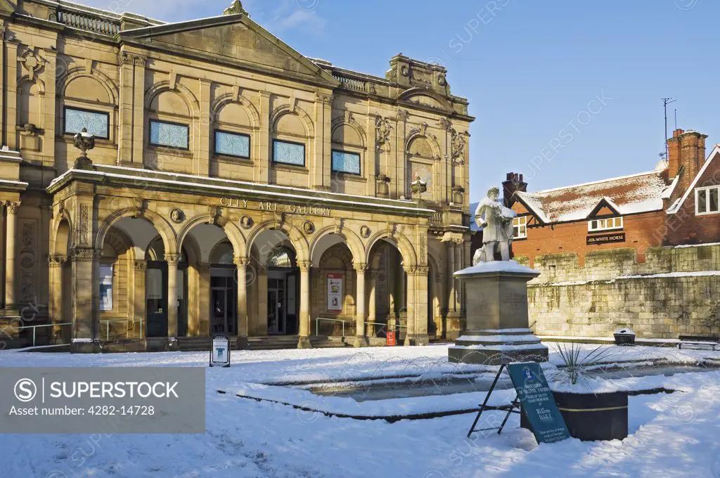 England, North Yorkshire, York. The statue of York artist William Etty, erected in 1911, in the snow covered Exhibition Square outside York Art Gallery (City Art Gallery) in winter.