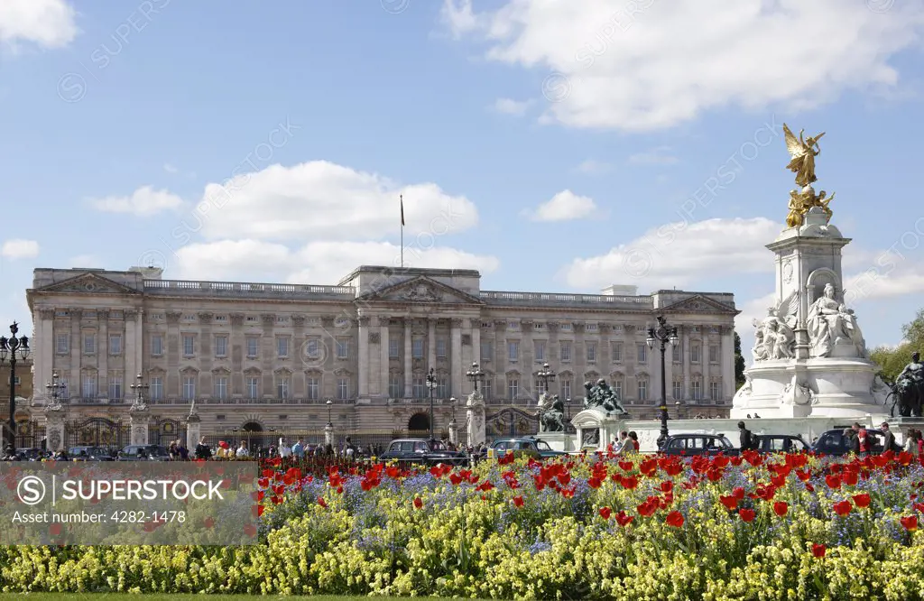 England, London, Buckingham Palace. The Victoria Memorial in front of Buckingham Palace with tulips in the foreground.