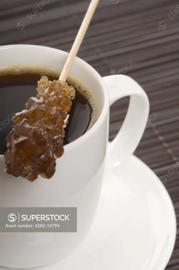 , . Cup of black coffee and sugar stick.