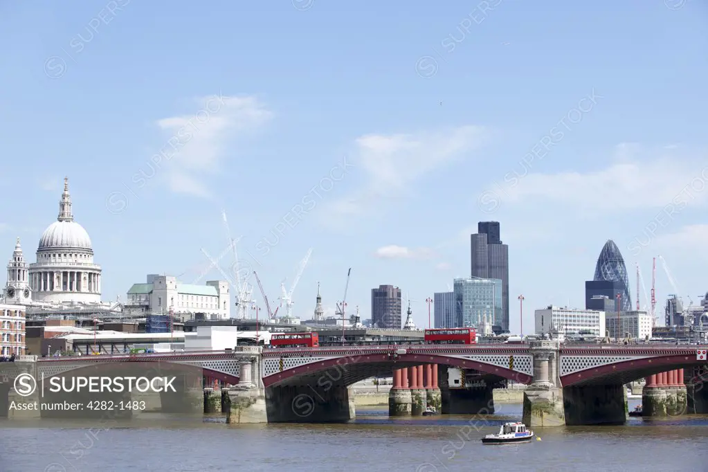 England, London, City of London. View of Blackfriars Bridge with a red bus and the City of London providing the backdrop.
