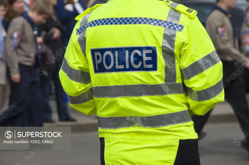 England, North Yorkshire, York. Back view of a police officer on duty wearing a fluorescent jacket at the annual Saint George's Day parade.