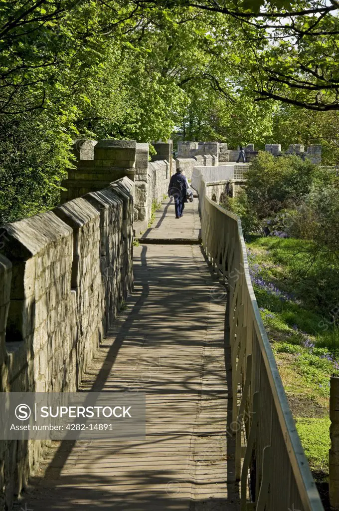 England, North Yorkshire, York. Tourists enjoying a walk on the historic York city walls.