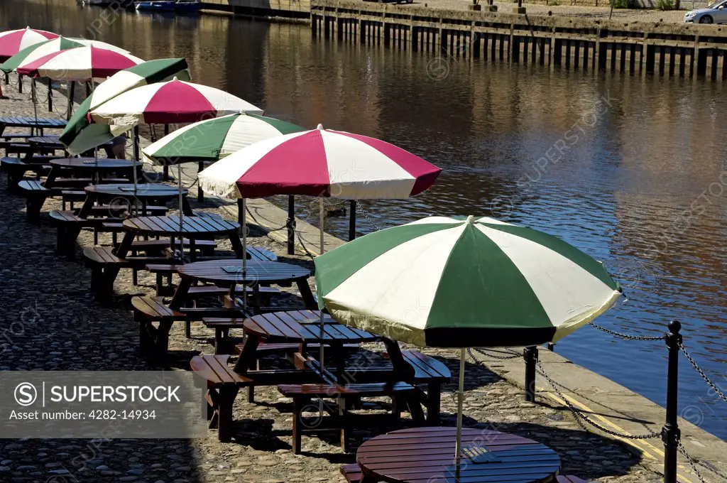 England, North Yorkshire, York. A row of tables with umbrellas outside the King's Arms pub by the River Ouse.
