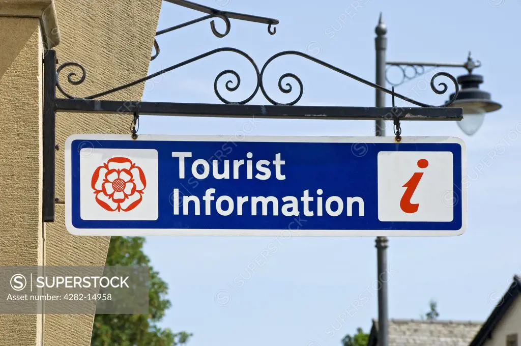 England, Cumbria, Grange-over-Sands. Tourist information sign hanging on wall outside visitor centre.