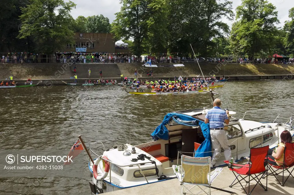 England, North Yorkshire, York. Watching boats cross the finishing line in the Dragon Boat Challenge on the River Ouse.