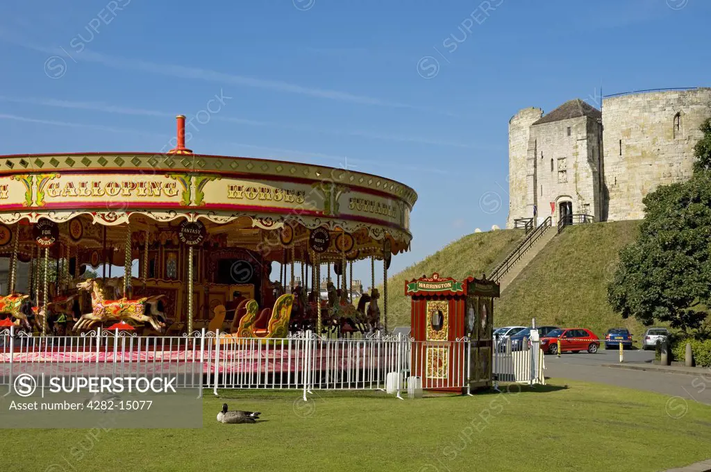 England, North Yorkshire, York. A carousel by Clifford's Tower in summer.