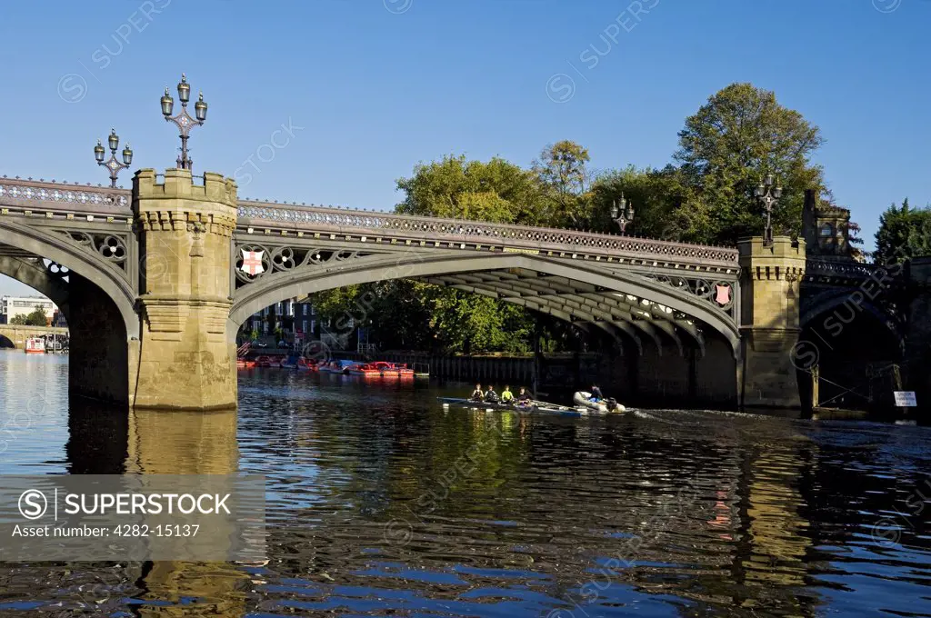 England, North Yorkshire, York. Rowers sculling on the River Ouse at Skeldergate Bridge.