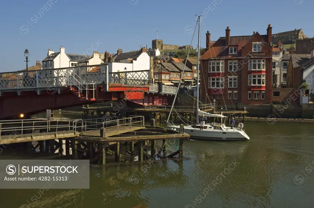 England, North Yorkshire, Whitby. A yacht passing through the swing bridge in Whitby.