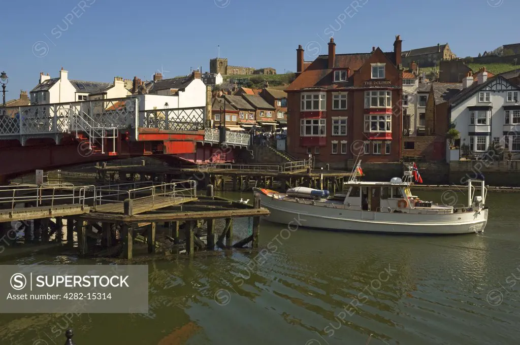 England, North Yorkshire, Whitby. A boat passing through the swing bridge in Whitby.