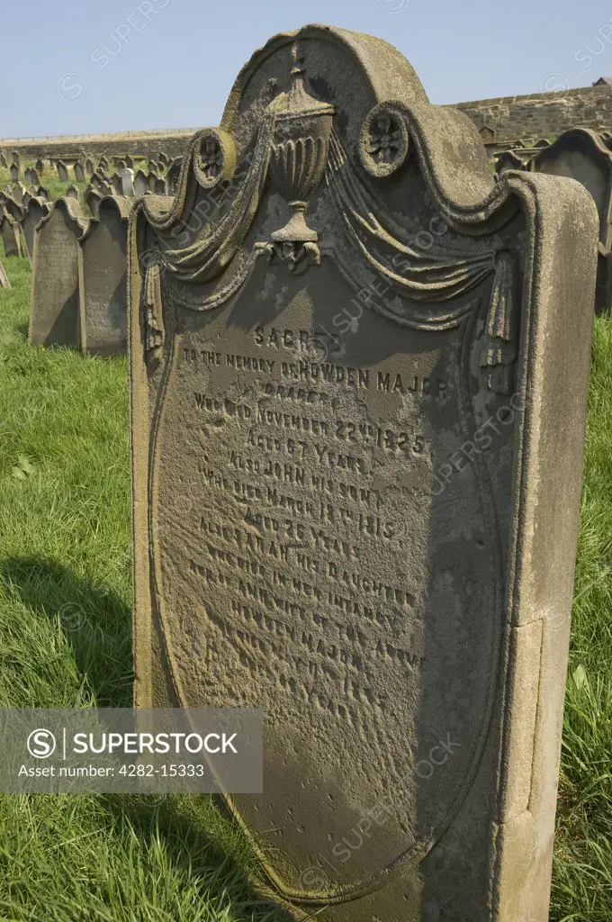 England, North Yorkshire, Whitby. A weathered headstone in St Mary's churchyard.